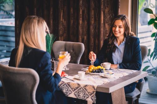 two women sitting at a table eating food at Plaza Hotel Plovdiv in Plovdiv