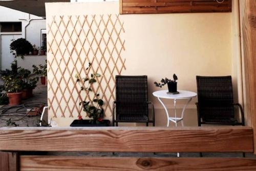 Habitación con 2 sillas y mesa con mesa en Summer aura - seaside place, en Istron