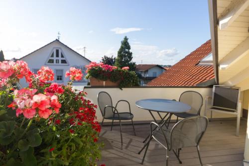 a patio with a table and chairs and flowers at Gästehaus Burgblick in Bisingen