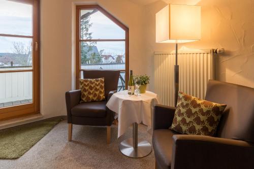 a room with a table and two chairs and a lamp at Gästehaus Burgblick in Bisingen