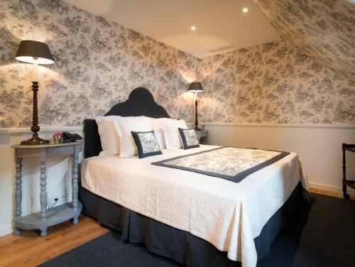 a bedroom with a large bed with floral wallpaper at Canalside House - Luxury Guesthouse in Bruges