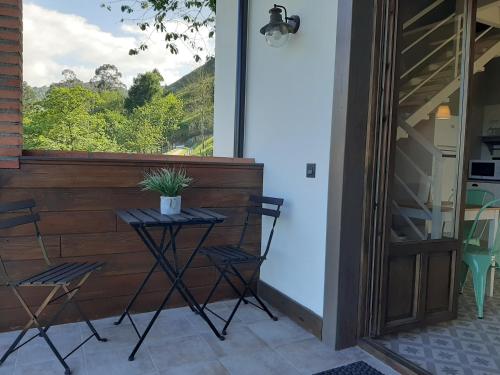 a patio with a table and chairs and a window at Apartamentos El Llanin in Cangas de Onís