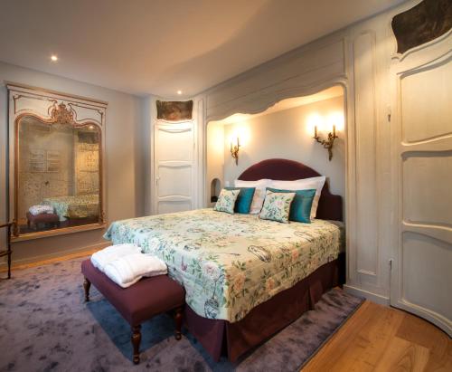 a bedroom with a bed and a mirror at Canalside House - Luxury Guesthouse in Bruges