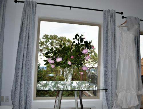 a vase of flowers on a table in front of a window at Armand Heights in Ganges