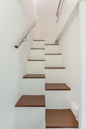 a staircase in a house with white walls and wooden treads at Cala Cala Rooms,Restaurant & Farm Experience in Procida