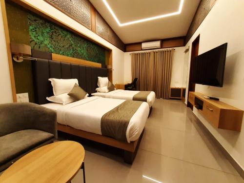 a hotel room with two beds and a television at Lago Leisure Resort & Spa in Cherai Beach
