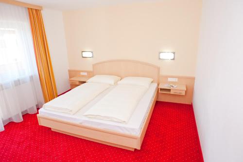 a bedroom with a bed with a red carpet at Sun Valley - Wildschönau in Auffach