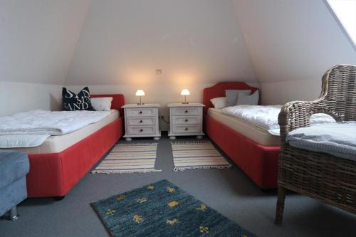 a room with two beds and two chairs in a attic at Kranichrast 1 Whg 4 in Zingst