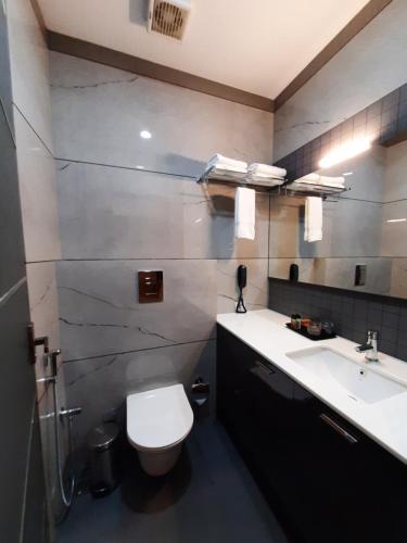a bathroom with a toilet and a sink at Lago Leisure Resort & Spa in Cherai Beach