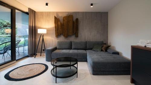 uma sala de estar com um sofá e uma mesa em Apartamenty Sun & Snow Kalinowa z sauną em Szczyrk