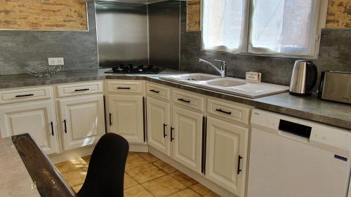 una cucina con mobili bianchi e un lavandino di Salamandre 2 proche de Sarlat de 1 à 5 personnes a Saint-André-dʼAllas