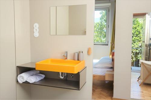 a bathroom with a yellow sink and a mirror at Casa da Oliveira in Caminha