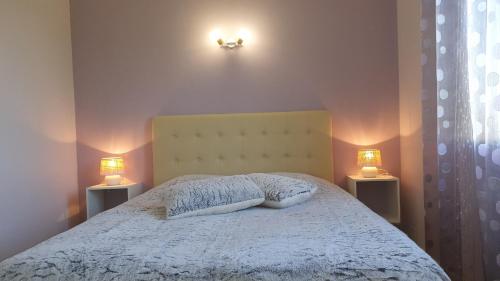una camera da letto con un letto con due luci sul muro di Salamandre 2 proche de Sarlat de 1 à 5 personnes a Saint-André-dʼAllas