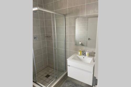 a bathroom with a shower and a sink and a mirror at The Blyde Silverlakes in Boschkop