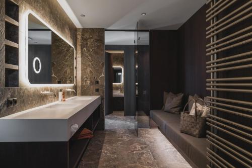 a bathroom with a large sink and a couch at Neuhaus Zillertal Resort in Mayrhofen
