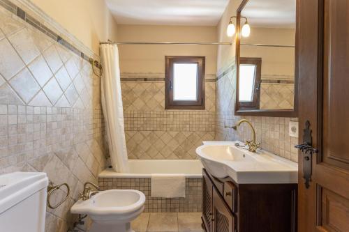 a bathroom with a sink and a toilet and a tub at Villa Natalia in Nerja