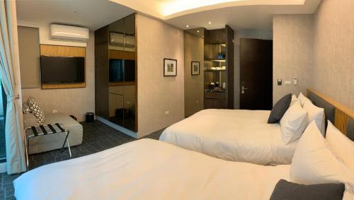 a hotel room with two beds and a flat screen tv at Tsang Kuo Resort in Wujie