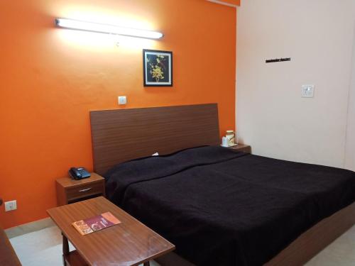a bedroom with a bed and a wooden table at Hotel Shikhar & Restaurant in Almora