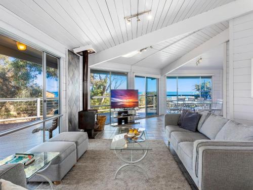 a living room with a couch and a tv at Coorumbene 8 Scenic Way in Normanville