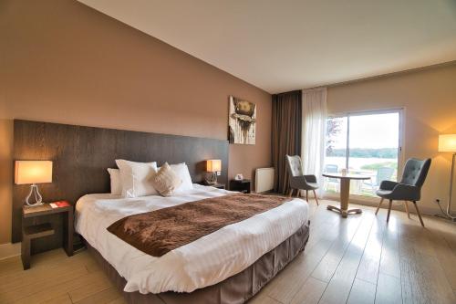 une chambre d'hôtel avec un grand lit et une grande fenêtre dans l'établissement Hôtel du Golf de l'Ailette, The Originals Relais, à Chamouille