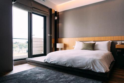 a bedroom with a large bed and a large window at Tsang Kuo Resort in Wujie