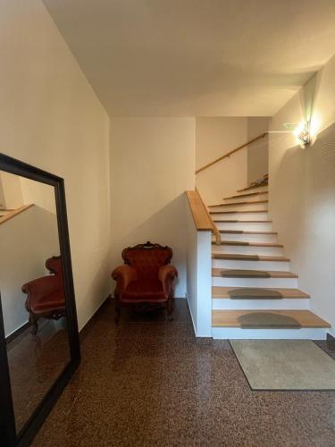 a hallway with a staircase with a mirror and a chair at undertheroof at in Salzburg