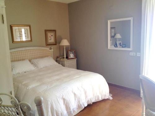 a bedroom with a white bed and a mirror at Seaside villa in Jávea with private pool in Jávea