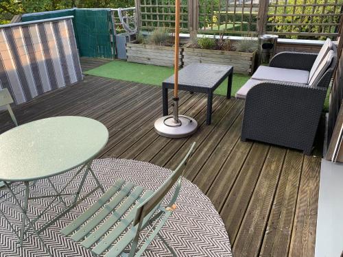 a wooden deck with two tables and chairs on it at Le Lagon in Jargeau