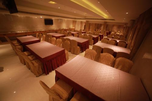 an empty auditorium with tables and chairs and a screen at THE HOTEL PARK in Kolachel