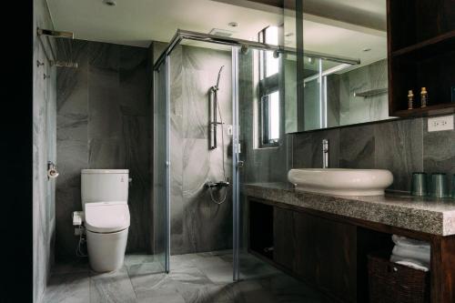 a bathroom with a toilet and a sink and a shower at Tsang Kuo Resort in Wujie