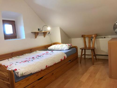 a small bedroom with a bed and a chair at Ferienhaus "Spatzennest" Eifel Gerolstein Hunde ok in Oberbettingen