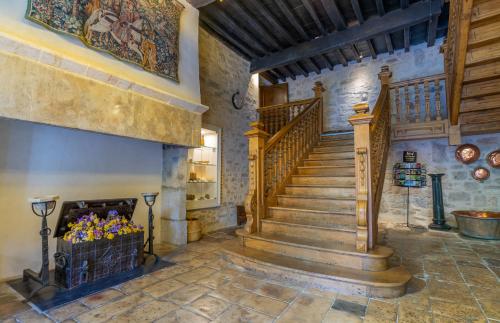 a stone staircase in a house with a fireplace at Hotel Beau Site - Rocamadour in Rocamadour