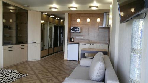 a living room with a couch and a kitchen at Apartment near Dnipro Arena in Dnipro