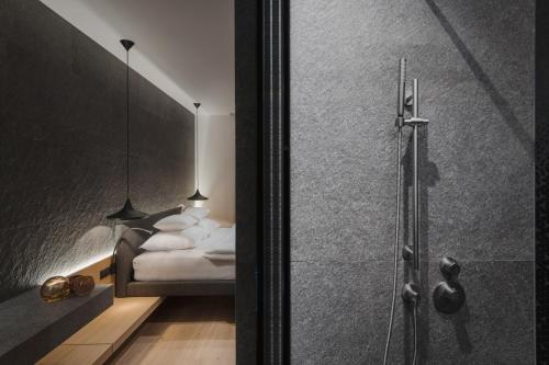 a bedroom with a bed and a glass shower at Neuhaus Zillertal Resort in Mayrhofen