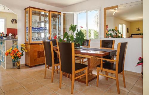 a dining room with a wooden table and chairs at Stunning Home In Puisserguier in Puisserguier