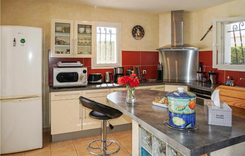 a kitchen with a white refrigerator and a counter top at Stunning Home In Puisserguier in Puisserguier