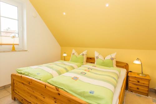 a bedroom with two beds with green and white pillows at Deichweg 12 in Zingst