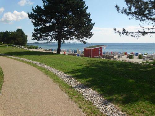 einen Fußweg neben einem Strand mit einem Baum und einem Pfad in der Unterkunft Apartementhaus Panoramic in Sierksdorf