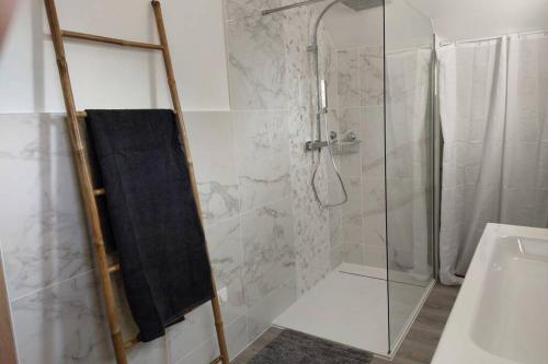 La salle de bains est pourvue d'une douche avec une porte en verre. dans l'établissement Gîte au cœur des Combrailles, à Saint-Georges-de-Mons