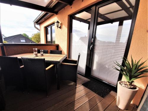 a patio with a table and chairs on a balcony at Ferienwohnung Summer in Karlshagen