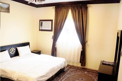 a bedroom with a bed and a large window at العييرى للوحدات المفروشة تبوك6 in Tabuk