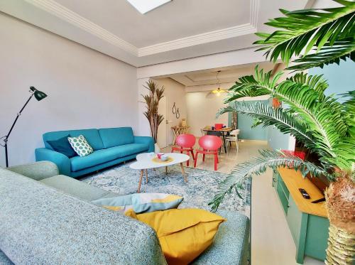 a living room with a blue couch and a table at Aromas Suites Apartments in Puerto de la Cruz