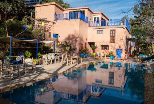 a house with a pool in front of a building at Auberge le Maquis in Aghbalou