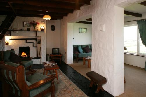 a living room with a couch and a fireplace at Doonbeg Holiday Cottages in Doonbeg