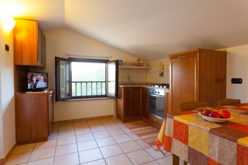 a kitchen with a table with a bowl of fruit on it at Agriturismo La Panoramica in Assisi
