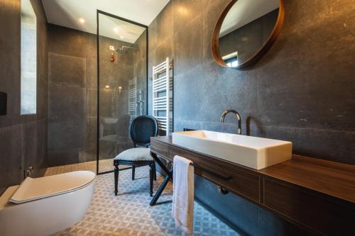 a bathroom with a sink and a toilet and a mirror at DESIGN hotel VERBENICUM in Vrbnik
