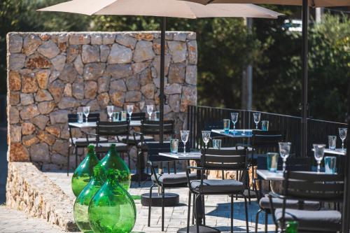 an outdoor restaurant with tables and chairs with wine glasses at DESIGN hotel VERBENICUM in Vrbnik