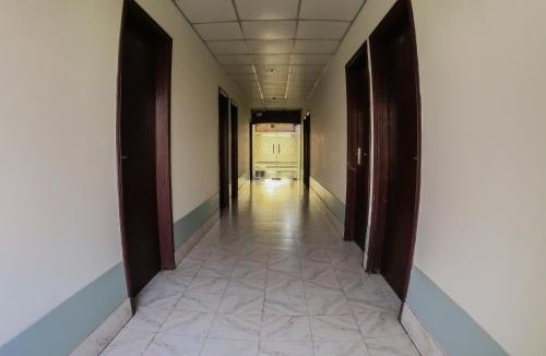 an empty hallway with brown doors and a tile floor at HOTEL HERITAGE in Chittagong