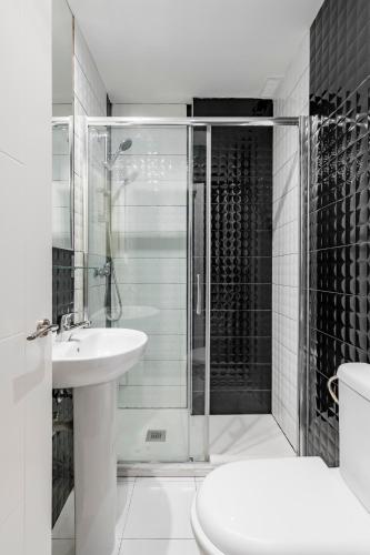 a bathroom with a shower and a toilet and a sink at Hostal Los Ángeles in Madrid