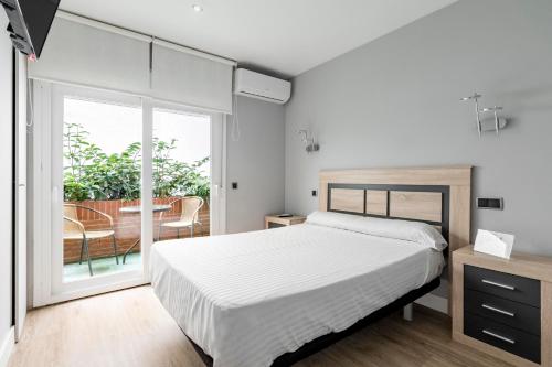 sypialnia z łóżkiem i balkonem w obiekcie Hostal Los Ángeles w Madrycie